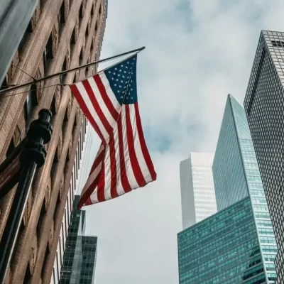 Uma bandeira dos Estados Unidos tremulando em frente a um conjunto de condomínios americanos.