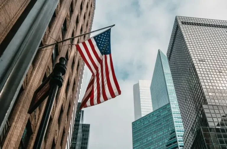 Uma bandeira dos Estados Unidos tremulando em frente a um conjunto de condomínios americanos.