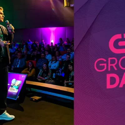 Rodrigo Monteiro, o CEO da Group Software, está no palco do Group Day, interagindo com o público em um ambiente iluminado com luzes coloridas.