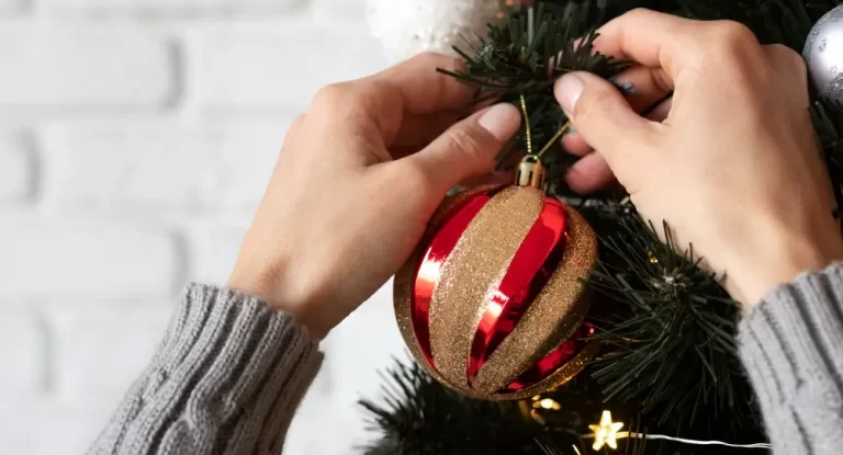 Uma pessoa decorando uma árvore de Natal em condomínios.