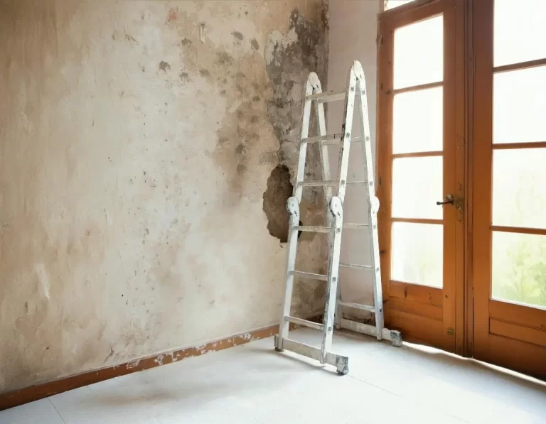 Parede de um apartamento com sinais de infiltração no condomínio acompanhada de uma escada, indicando que reparos estão em andamento.